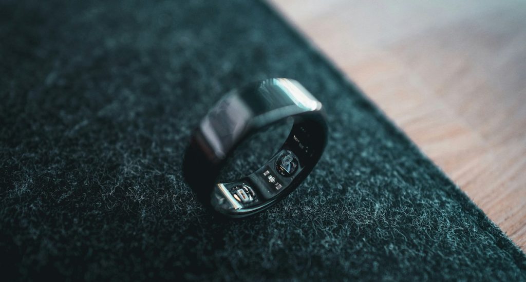 Black Oura Ring closeup on dark table.